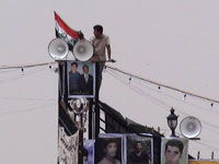 Agents du Vevak installant des panneaux de propagande et des haut-parleurs sur le portail de l'entrée principale d'Achraf