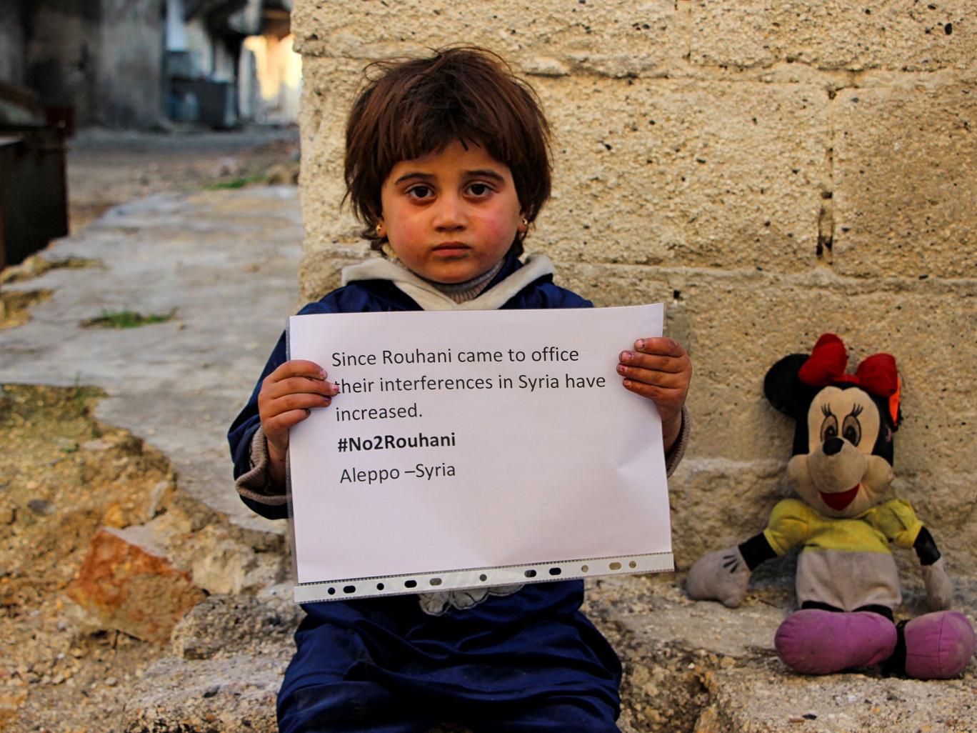 Des enfants syriens manifestent dans la ville détruite d’Alep contre l’intervention de l’Iran, pendant la visite du président Rohani en Europe