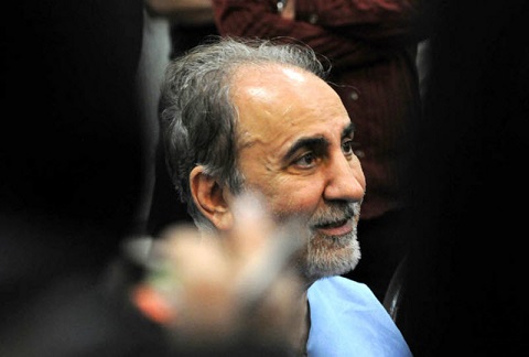 Un ancien responsable iranien boit du thé avec les policiers après s'être rendu pour le meurtre de sa femme